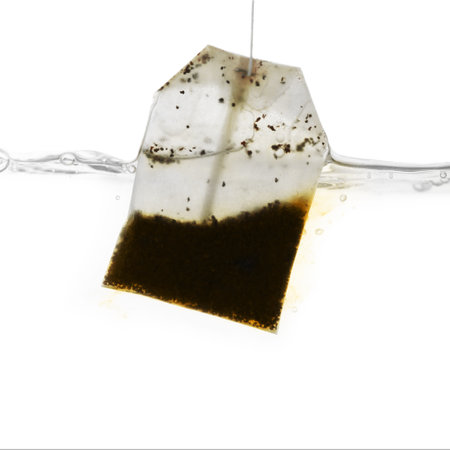 Putting tea bag into glass cup on white background, closeupの写真素材