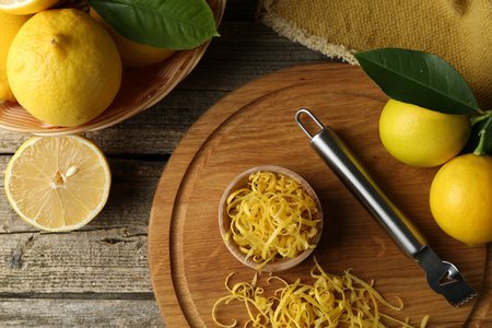 Lemon zest, zester tool and fresh fruits on wooden table, flat layの写真素材