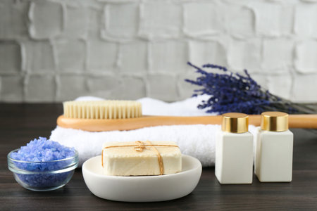 Spa treatment. Composition with cosmetic products and towel on wooden table