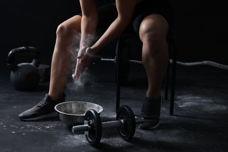 Woman applying talcum powder onto hands before training in gym, closeupの写真素材