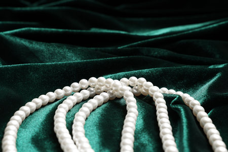 Beautiful pearl necklace on green cloth, closeupの写真素材