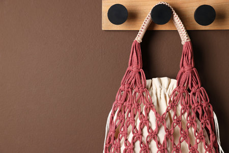 Handmade macrame shopping bag on brown wall, space for textの写真素材