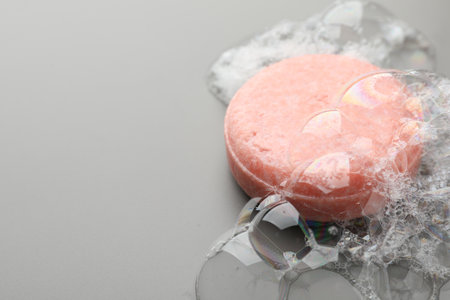 Soap bar with foam on grey background, closeup. Space for textの写真素材
