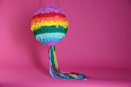 Colorful pinata on bright pink background, space for textの写真素材