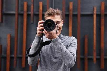 Professional photographer taking picture with camera outdoors