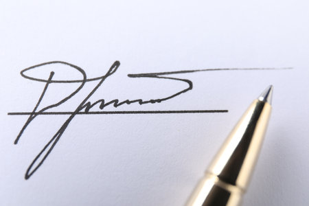 Pen and signature on white paper, closeupの写真素材