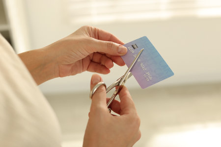 Woman cutting plastic credit card indoors, closeupの写真素材
