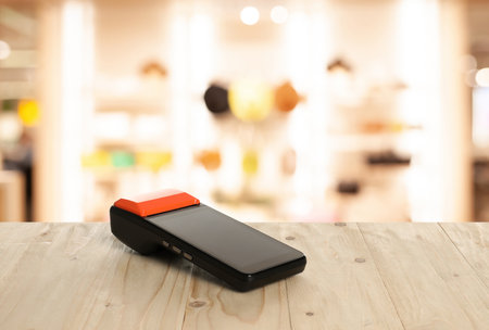 Payment terminal on wooden counter in store