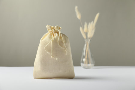 Beige burlap sack on white surface against gray backgroundの写真素材