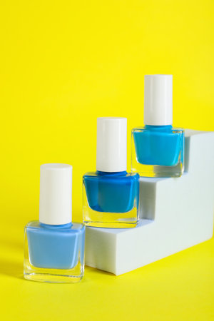Stylish presentation of nail polishes in bottles on yellow backgroundの写真素材