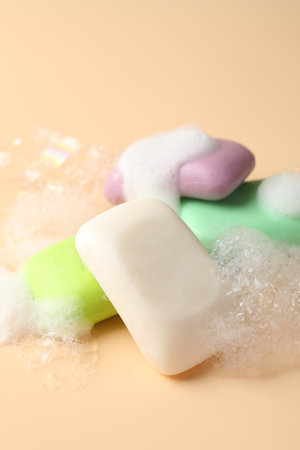 Soap bars with foam on beige background, closeupの写真素材