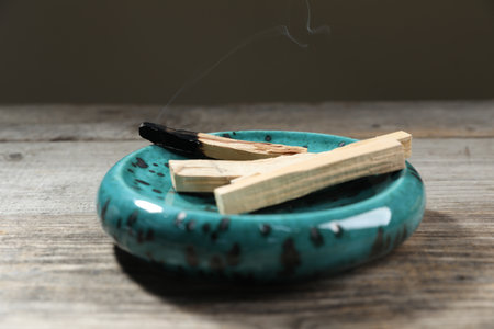 Smoldering incense sticks on a wooden surface, closeupの写真素材