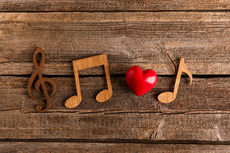 Red heart figure and notes on wooden table, flat layの写真素材
