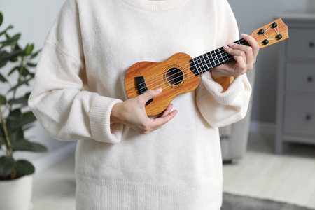Woman playing ukulele at home, closeup viewの写真素材