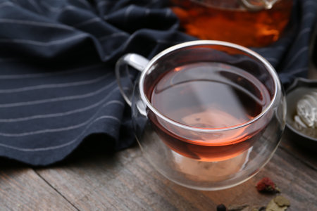 Delicious herbal tea and dry leaves on wooden table, closeupの写真素材