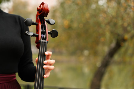 Woman with cello outdoors, closeup. Space for textの写真素材