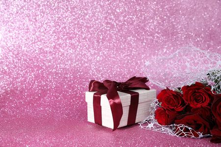 Romantic gift and roses on pink background. Space for textの写真素材