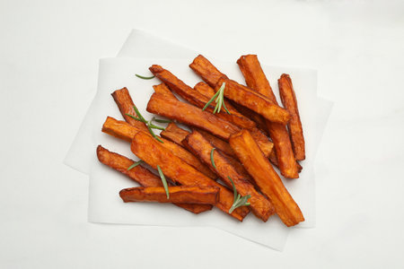 Sweet potato fries with rosemary on white marble table, top view