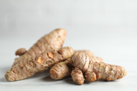 Raw turmeric roots on white marble table, closeupの写真素材