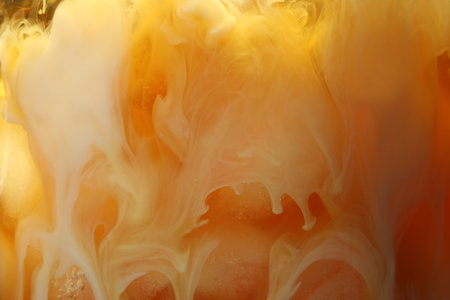 Refreshing coffee with ice and milk as background, closeup