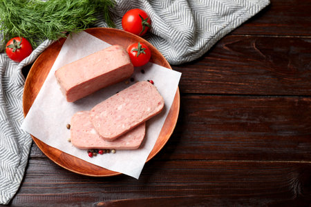 Pieces of tasty meat, tomatoes, dill and peppercorns on wooden table, flat lay. Space for textの写真素材