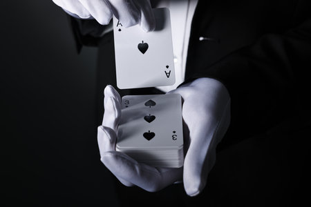 Illusionist shuffling playing cards on black background, closeupの写真素材