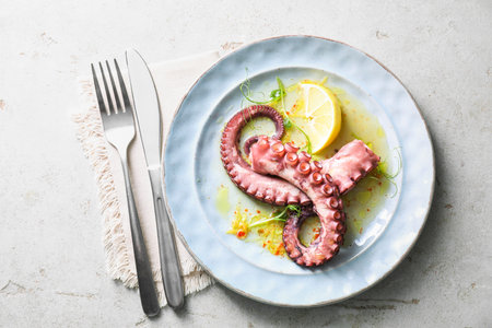 Appetizing octopus tentacles served on light table, top viewの写真素材