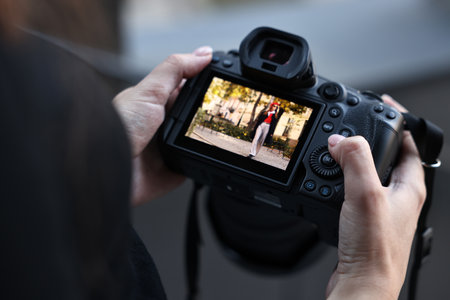 Professional photographer with digital camera outdoors, closeup