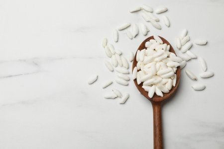 Spoon with puffed rice on white table, top view. Space for textの写真素材