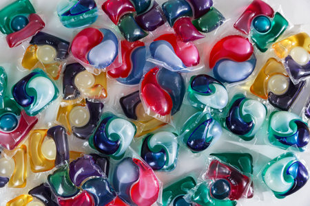 Different laundry detergent capsules on white background, top view