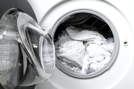 Open washing machine with clean clothes, closeupの写真素材
