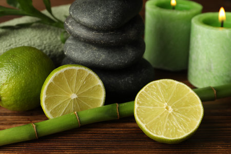 Spa composition with fresh limes, pebble stones and bamboo on wooden table, closeupの写真素材