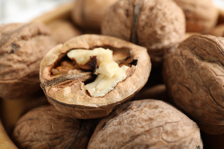 Fresh walnuts with shells on table, closeup