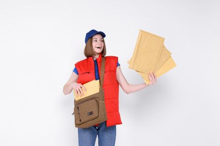 Happy postwoman with bag and envelopes on white backgroundの写真素材