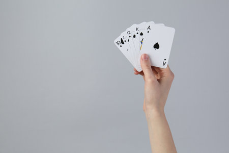 Woman with playing cards against gray background, closeup. Space for textの写真素材