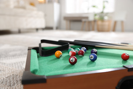 Many colorful billiard balls, triangle rack and cues on green table indoors, closeupの写真素材