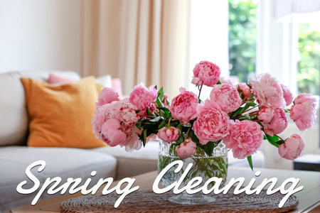Spring cleaning. Beautiful pink peonies in glass vase on tableの写真素材