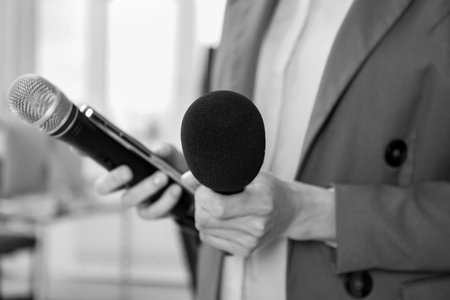 Journalist with microphones and mobile phone, closeup. Toned in black-and-whiteの写真素材