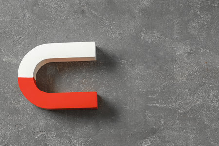 One horseshoe magnet on grey textured background, top view. Space for textの写真素材