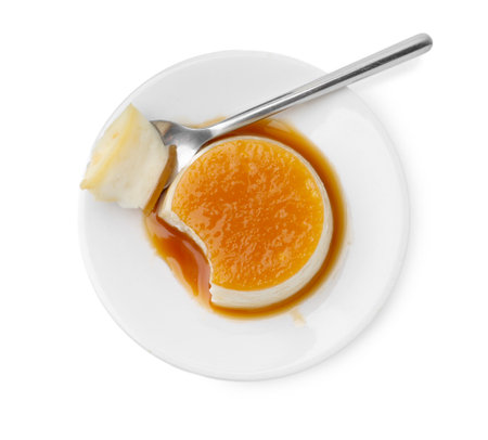 Tasty pudding with caramel sauce and spoon isolated on white, top viewの写真素材