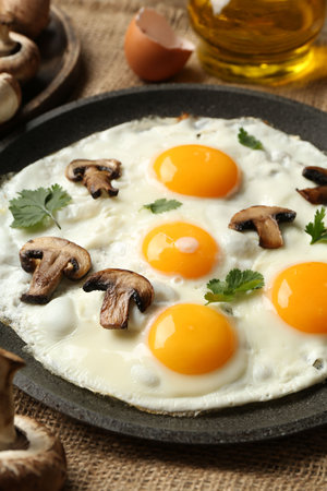 Tasty fried eggs with mushrooms and parsley served on table, closeupの写真素材