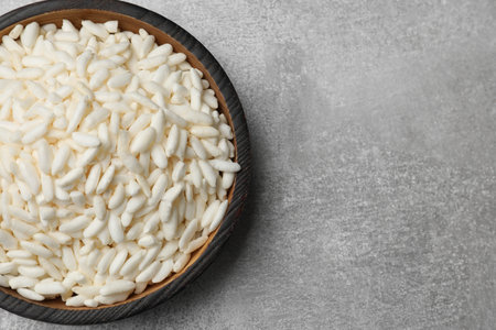 Puffed rice in bowl on light grey table, top view. Space for textの写真素材