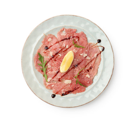 Delicious beef carpaccio with arugula, cheese, balsamic vinegar and lemon isolated on white, top viewの写真素材