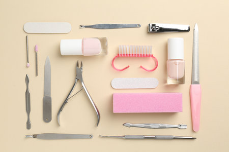 Set of pedicure tools on beige background, flat layの写真素材