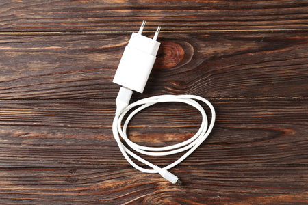 USB power adapter with charge cable on wooden table, top view