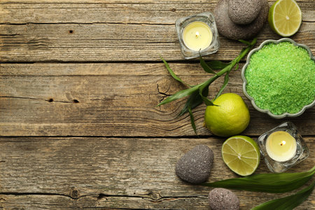 Spa composition with fresh limes, sea salt and burning candles on wooden table, flat lay. Space for textの写真素材
