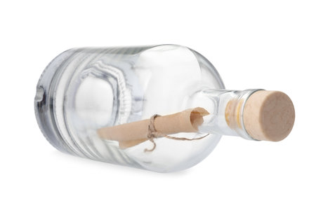 Corked glass bottle with rolled letter isolated on whiteの写真素材