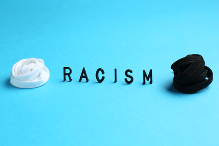 Word Racism and shoelaces of different colors on light blue backgroundの写真素材