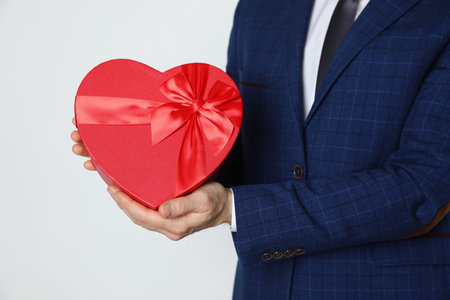 Happy Valentine's Day. Man with heart shaped gift box on white background, closeupの写真素材