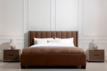 Large bed in mocha mousse shade and nightstands indoors. Trendy color of 2025 year in interior designの写真素材